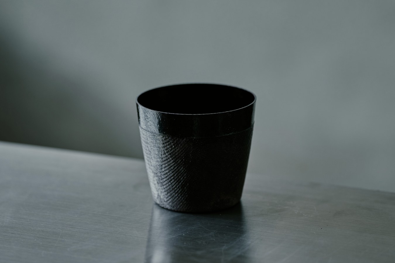 卓上に置かれた黒い器の形と表面の質感